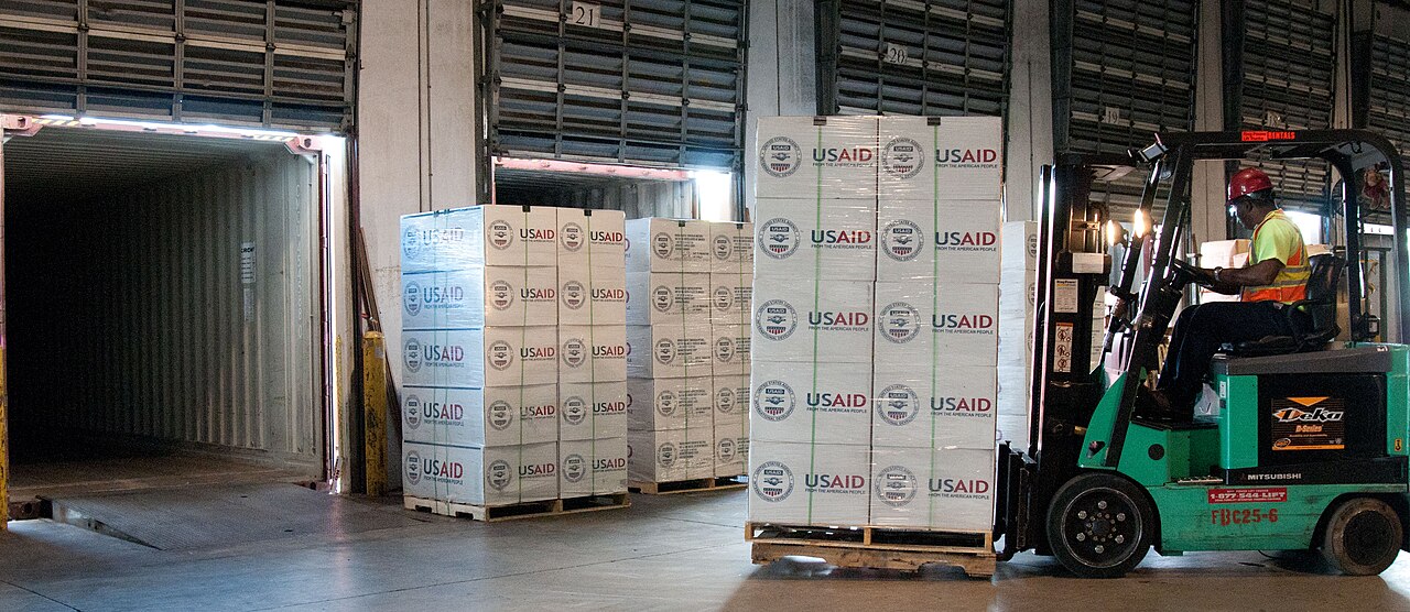 Forklifts moving goods across the floor of a large warehouse