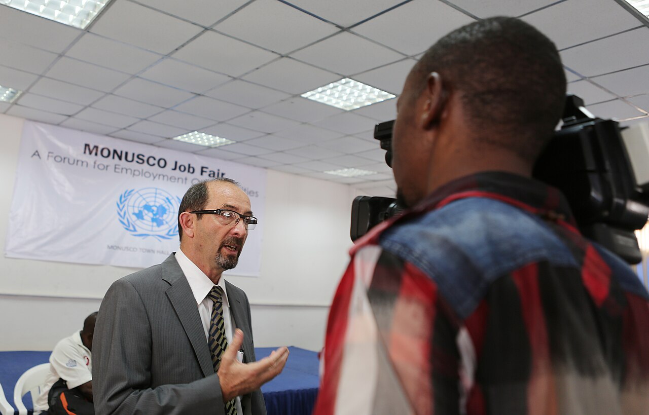 A speaker talking with an attendee at a job fair